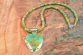 Genuine High Grade Kingman Web Turquoise set in Sterling Silver. Stunning Pendant and Necklace Set. The Turquoise Necklace features Turquoise and Jasper Rondelle beads with Sterling Silver Beads and Clasp. The Mineral Park Mine, in the Cerbat Mountains 14 miles northwest of Kingman, was first mined by Indians centuries before white man came to the area. It is one of the three sites of prehistoric mining localities in the state of Arizona. Mineral Park was the most extensively worked area by the Indians of the three. S.A. �Chuck� Colbaugh found a cache of stone hammers uncovered in ancient trenches and tunnels, when he had the turquoise mining concession in May of 1962. Ithaca Peak and Turquoise Mine (formally called Aztec Mountain or Aztec Peak) are the most famous of the peaks in the area containing turquoise. The photo is of the jewelry you will be receiving. Created by Navajo Artist Phillip Sanchez. Signed by the artist.